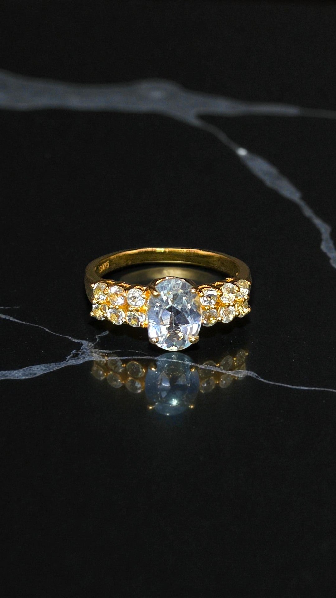 NYX – LARGE OVAL NATURAL BLUE TOPAZ GEMSTONE RING PLATED IN YELLOW GOLD