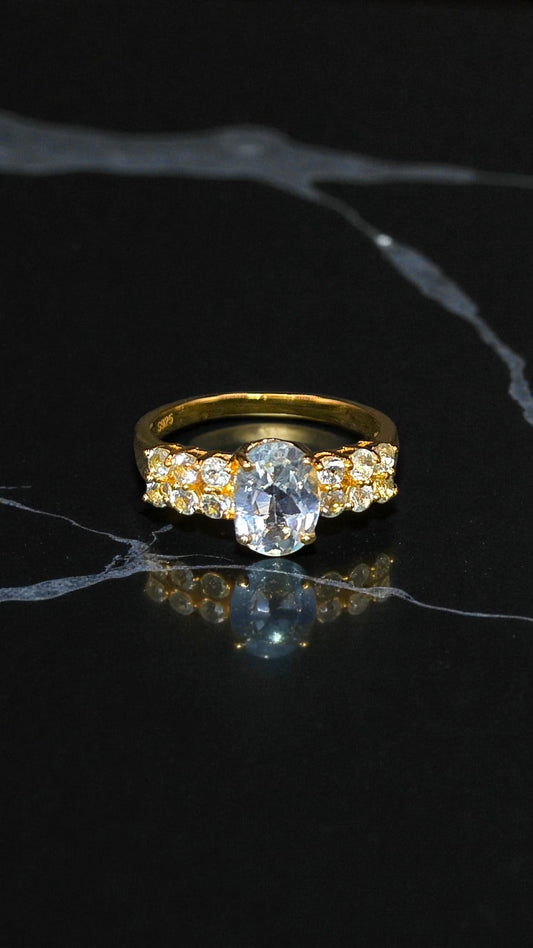 NYX – LARGE OVAL NATURAL BLUE TOPAZ GEMSTONE RING PLATED IN YELLOW GOLD
